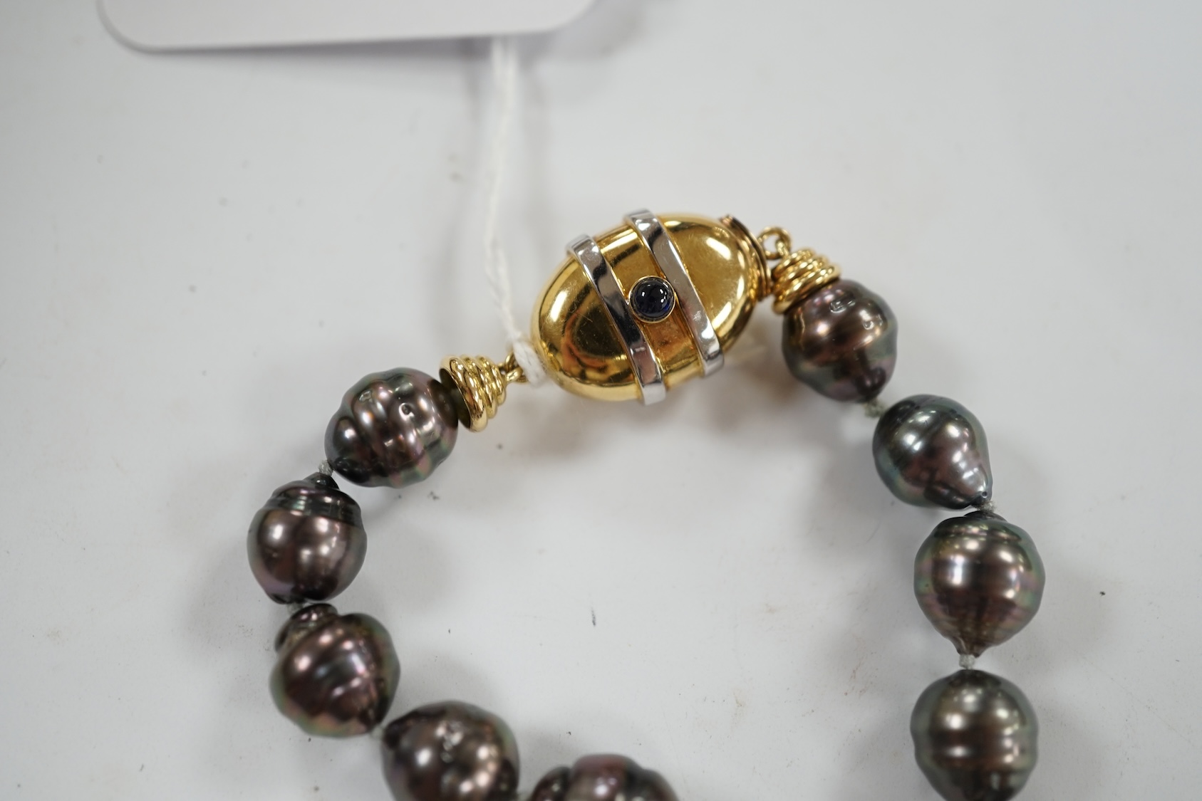 A modern single strand graduated Tahitian baroque cultured pearl necklace, with cabochon set yellow metal clasp, 48cm. Condition - fair to good